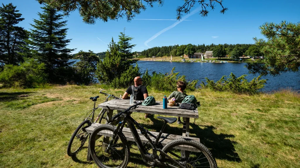 Grande traversée de l'Ardèche, deux cyclistes font une pause au lac de Devesset, en été