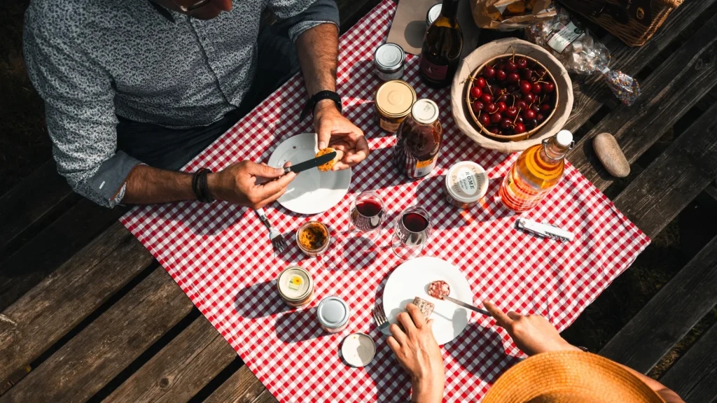 Couple partageant un pique-nique avec des produits "Goûtez l'Ardèche" en été