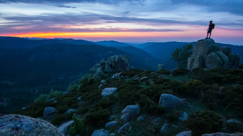 Homme observant le coucher de soleil sur les montagnes de Montselgues