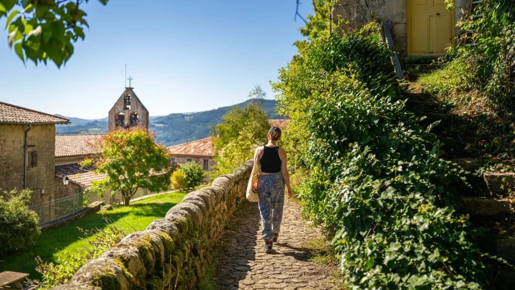 Femme dans une ruelle du village de caractère de Chalencon, en été
