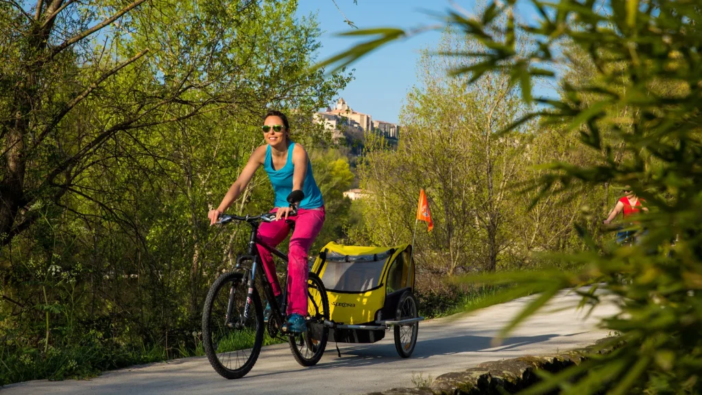 Jeune femme faisant du vélo sur la Via Ardèche, au niveau de Aubenas, au printemps