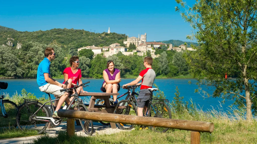 Friends taking a break near the ViaRhôna with Viviers in the background, in summer