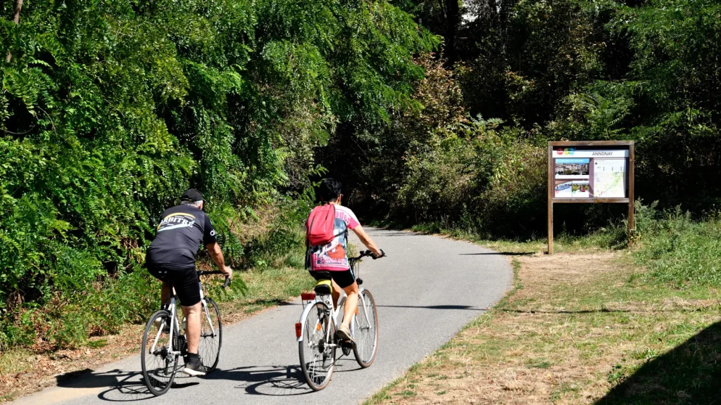 Couple à vélo sur la voie douce de la Via Fluvia, en été