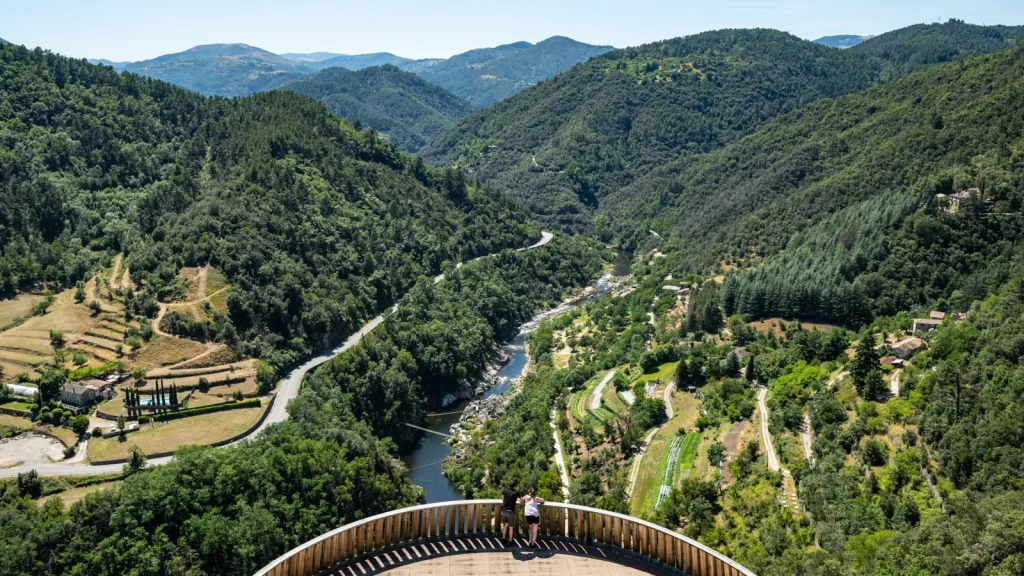 Couple at the Saint-Michel-de-Chabrillanoux belvedere, observing the view of the Eyrieux valley and the Dolce Via, in summer