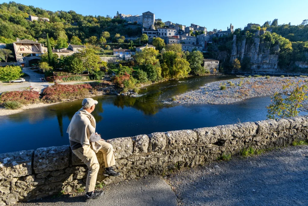Man looking at the vlllage with outstanding character of Balazuc, in autumn