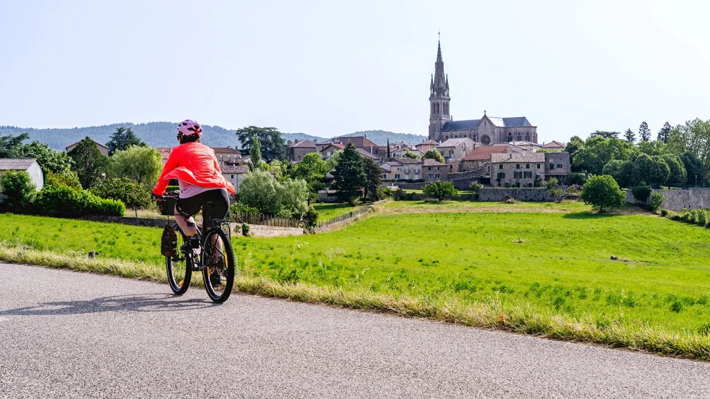 Femme à vélo devant Vernoux-en-Vivarais