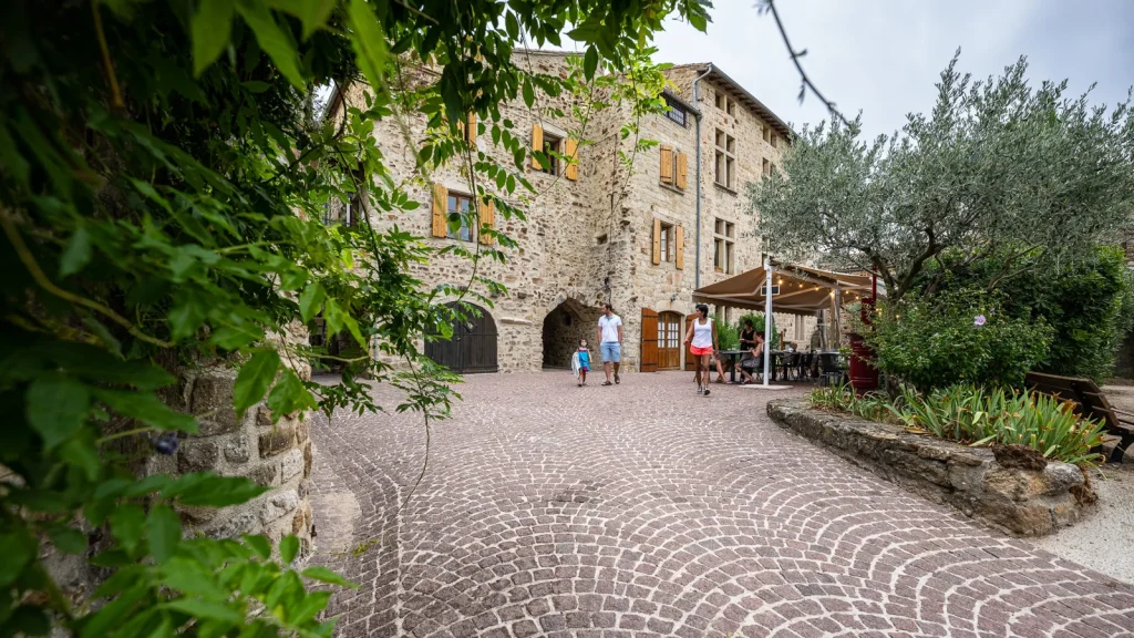 Famille flânant dans le village de caractère de Vinezac en été