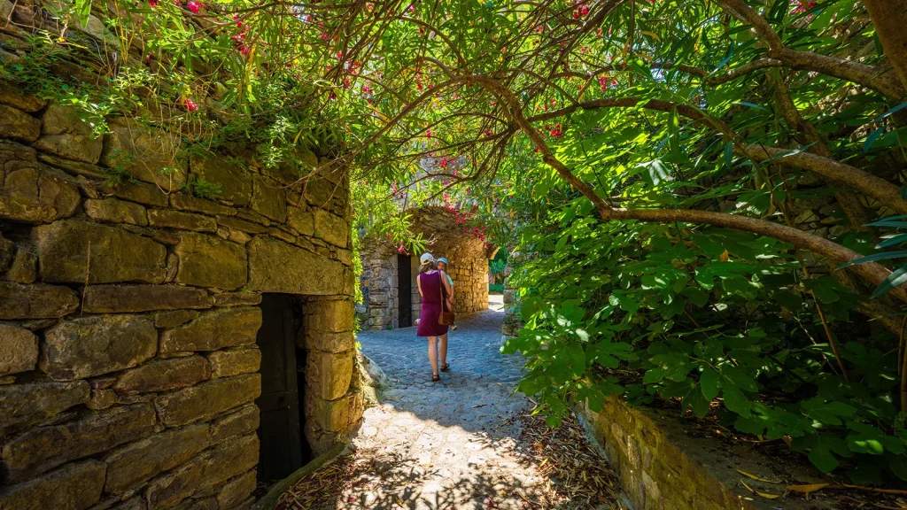 Femme avec enfant flânant dans les ruelles du village de caractère de Naves en été