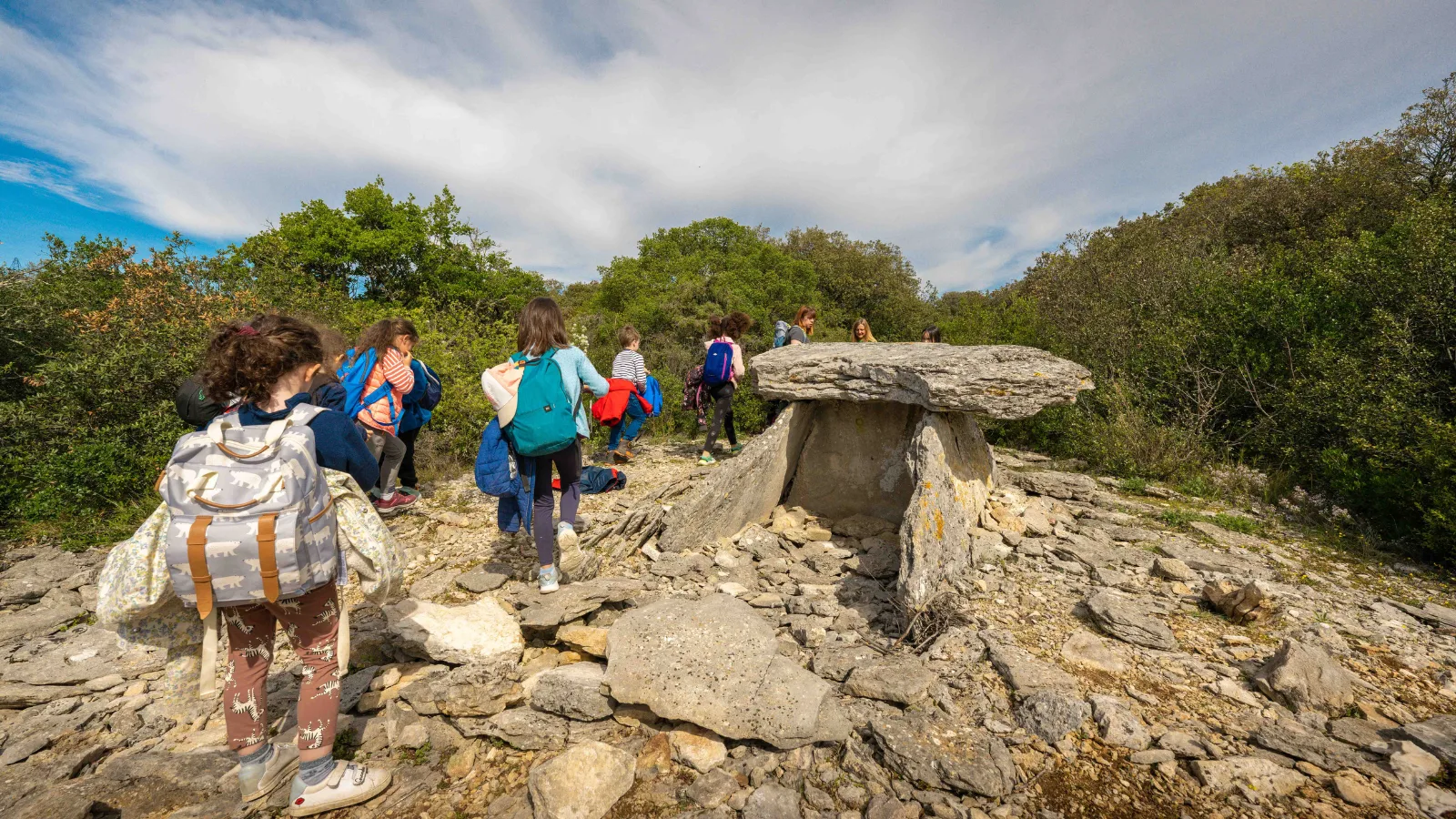 Groupe d'enfants en balade près d'un dolmen