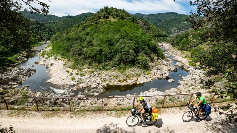 Hommes à vélo sur la Dolce Via, dans la vallée de l'Eyrieux, au printemps. En itinérance