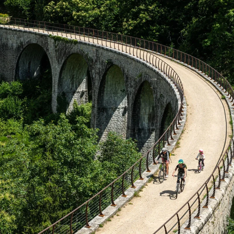 Famille à vélo sur la Dolce Via, dans la vallée de l'Eyrieux, en été