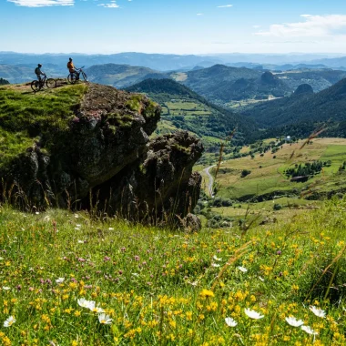Grande traversée de l'Ardèche - Deux hommes à VTT observent le panorama sur les Boutières, en été