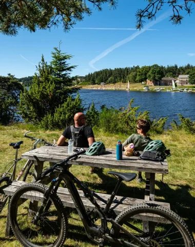 Grande traversée de l'Ardèche, deux cyclistes font une pause au lac de Devesset, en été