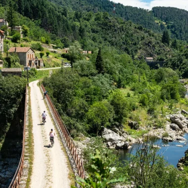 Personnes à vélo sur la Dolce Via, dans la vallée de l'Eyrieux, en été