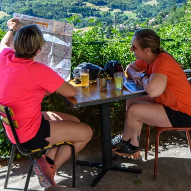 Femmes sur une terrasse, regardant la carte de l'Ardèche, en été