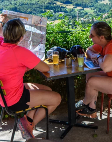 Femmes sur une terrasse, regardant la carte de l'Ardèche, en été