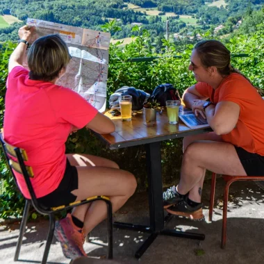 Femmes sur une terrasse, regardant la carte de l'Ardèche, en été
