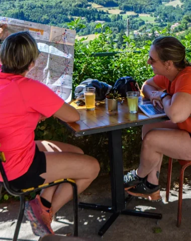 Femmes sur une terrasse, regardant la carte de l'Ardèche, en été