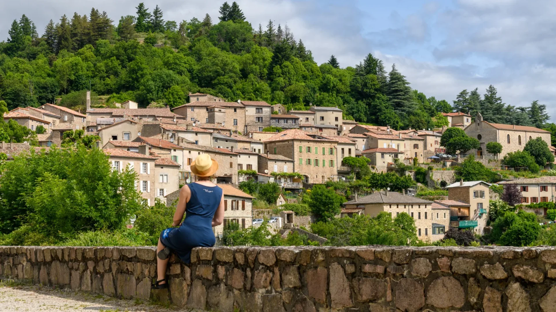 Femme observant une partie du village de caractère de Chalencon en été