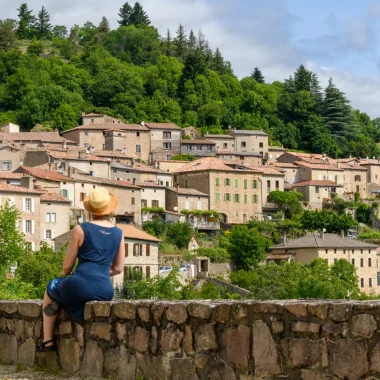 Femme observant une partie du village de caractère de Chalencon en été