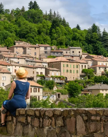 Femme observant une partie du village de caractère de Chalencon en été