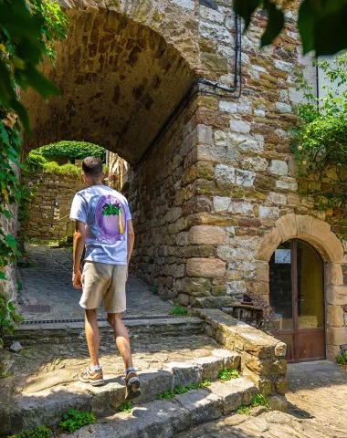 homme flânant dans les ruelles du village de caractère de Naves en été