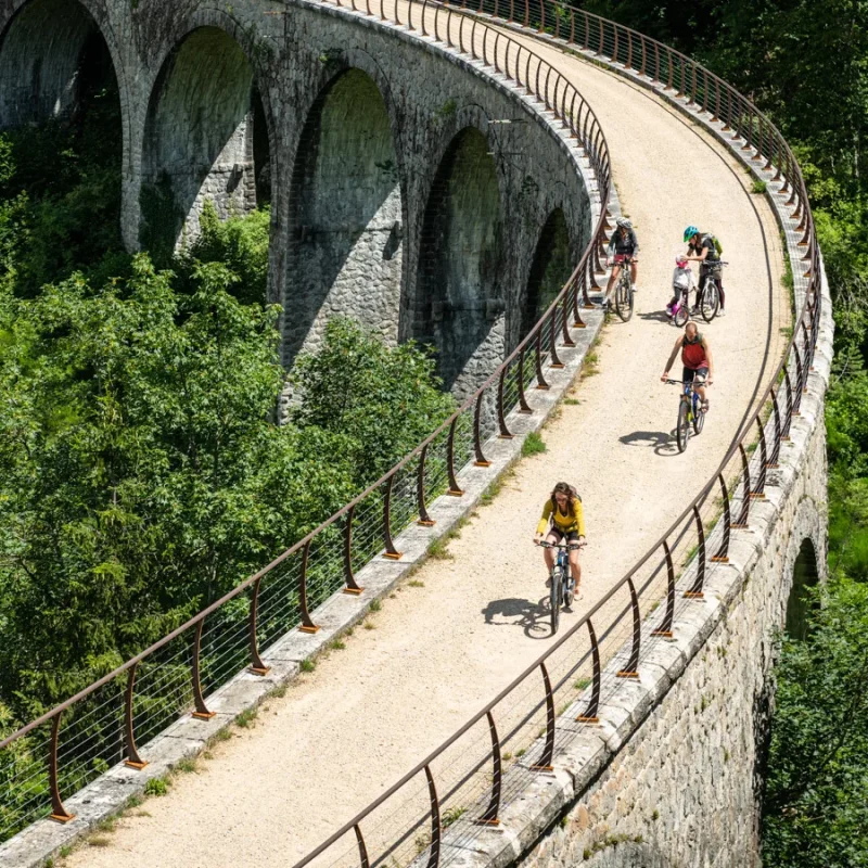 Famille à vélo sur la Dolce Via, dans la vallée de l'Eyrieux, en été