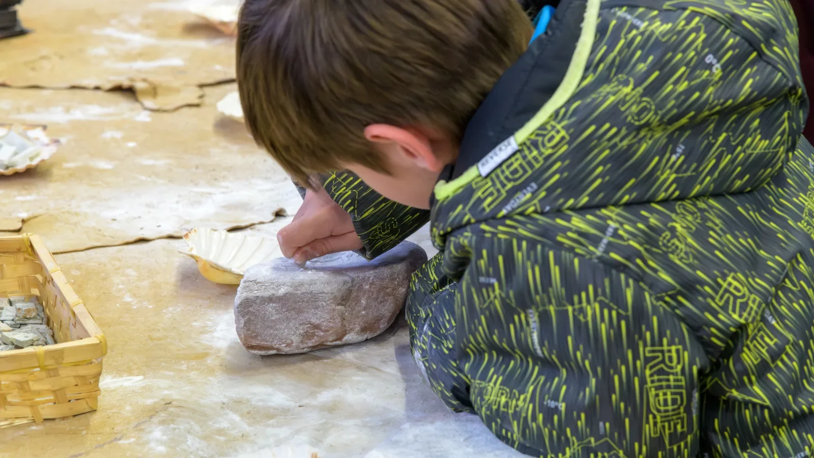 Enfant participant à une animation de l'Aven Orgnac : création de bijoux
