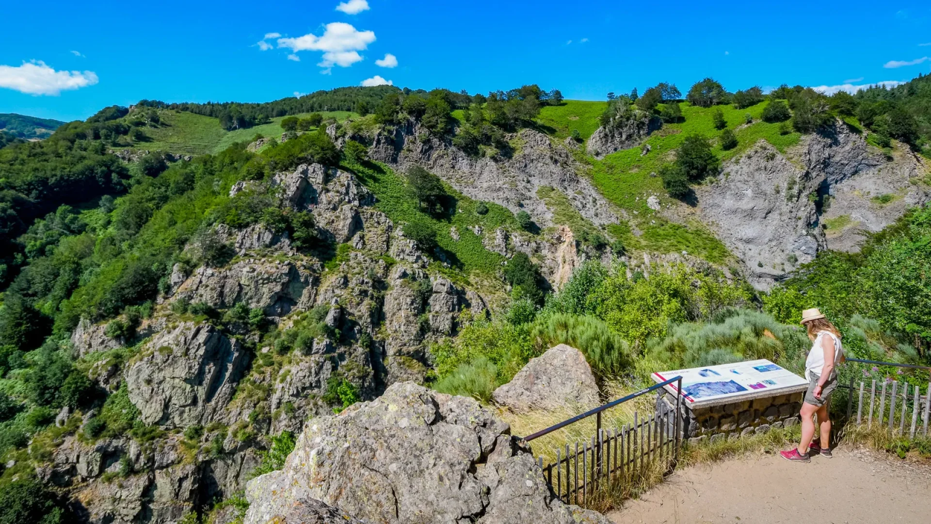 Femme regardant un panneau au belvédère sur le sentier de la cascade du Ray-Pic