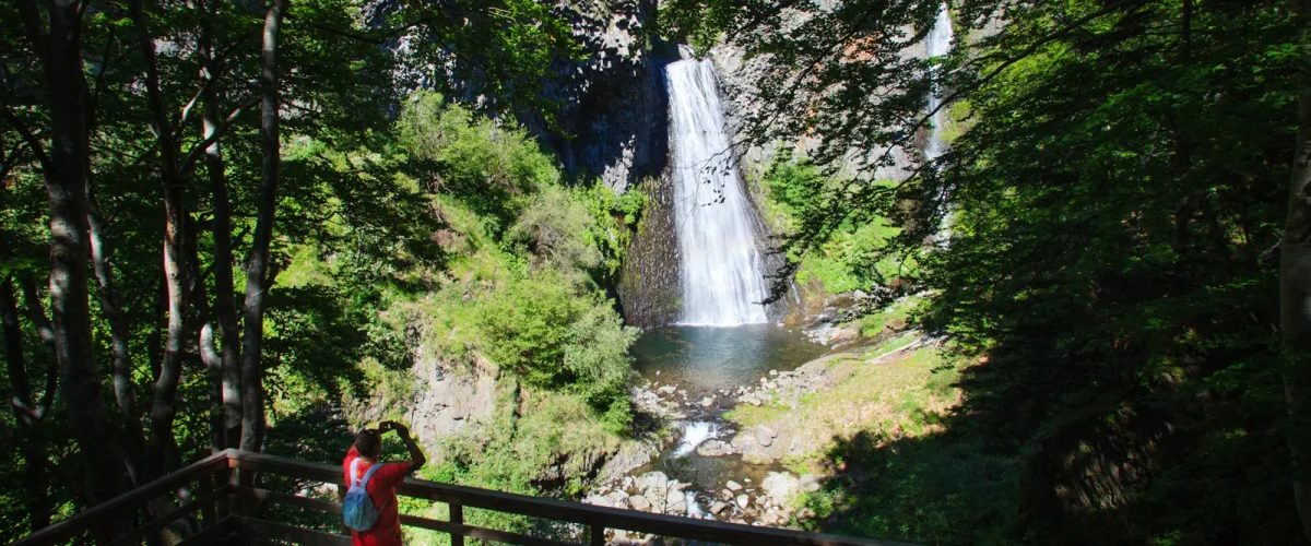 Homme prenant une photo de la cascade du Ray-Pic