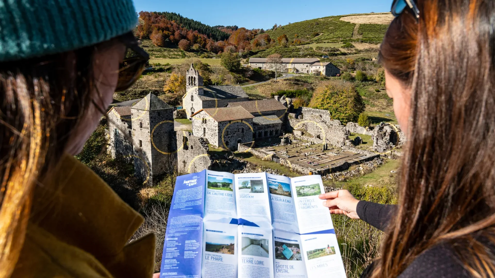 Femme observant une carte sur la ligne de partage des eaux, devant l'Abbaye de Mazan et l'œuvre de Felice Varini, en automne