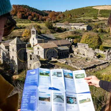 Femme observant une carte sur la ligne de partage des eaux, devant l'Abbaye de Mazan et l'œuvre de Felice Varini, en automne