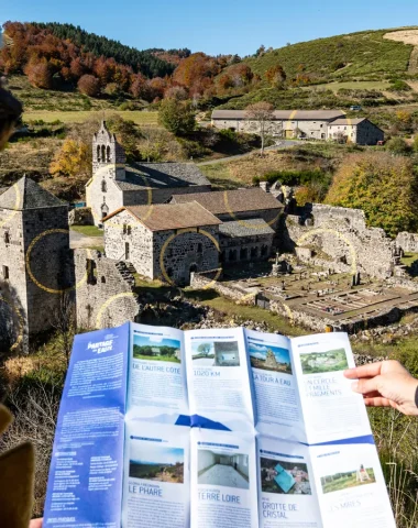 Femme observant une carte sur la ligne de partage des eaux, devant l'Abbaye de Mazan et l'œuvre de Felice Varini, en automne