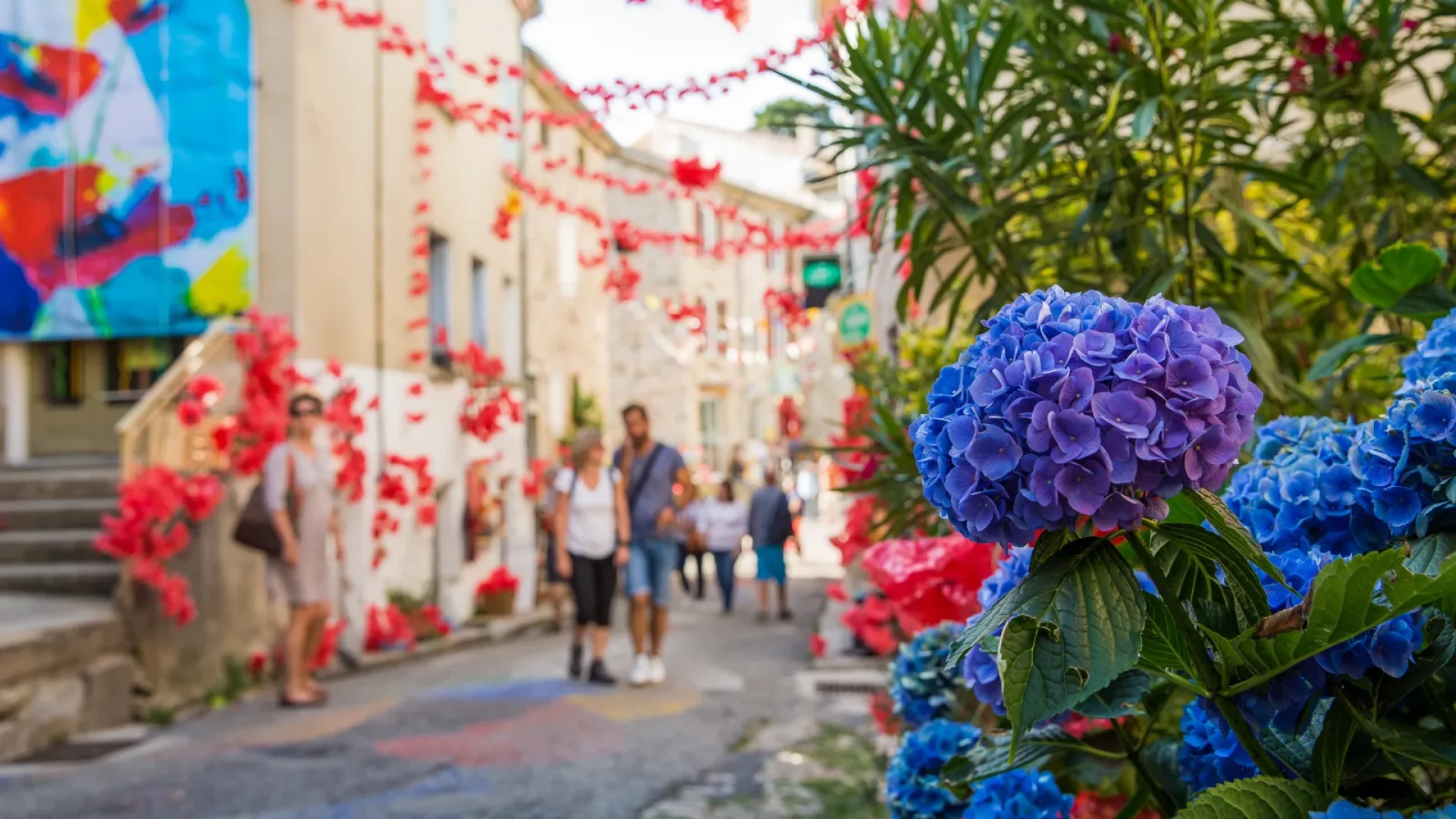 Personnes déambulant dans une ruelle décorée pour un festival