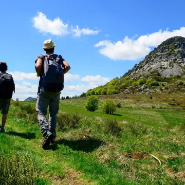Un homme et son fils randonnant devant le Mont Gerbier de Jonc au printemps