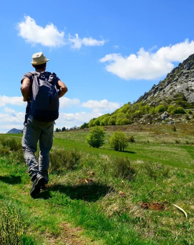 Un homme et son fils randonnant devant le Mont Gerbier de Jonc au printemps