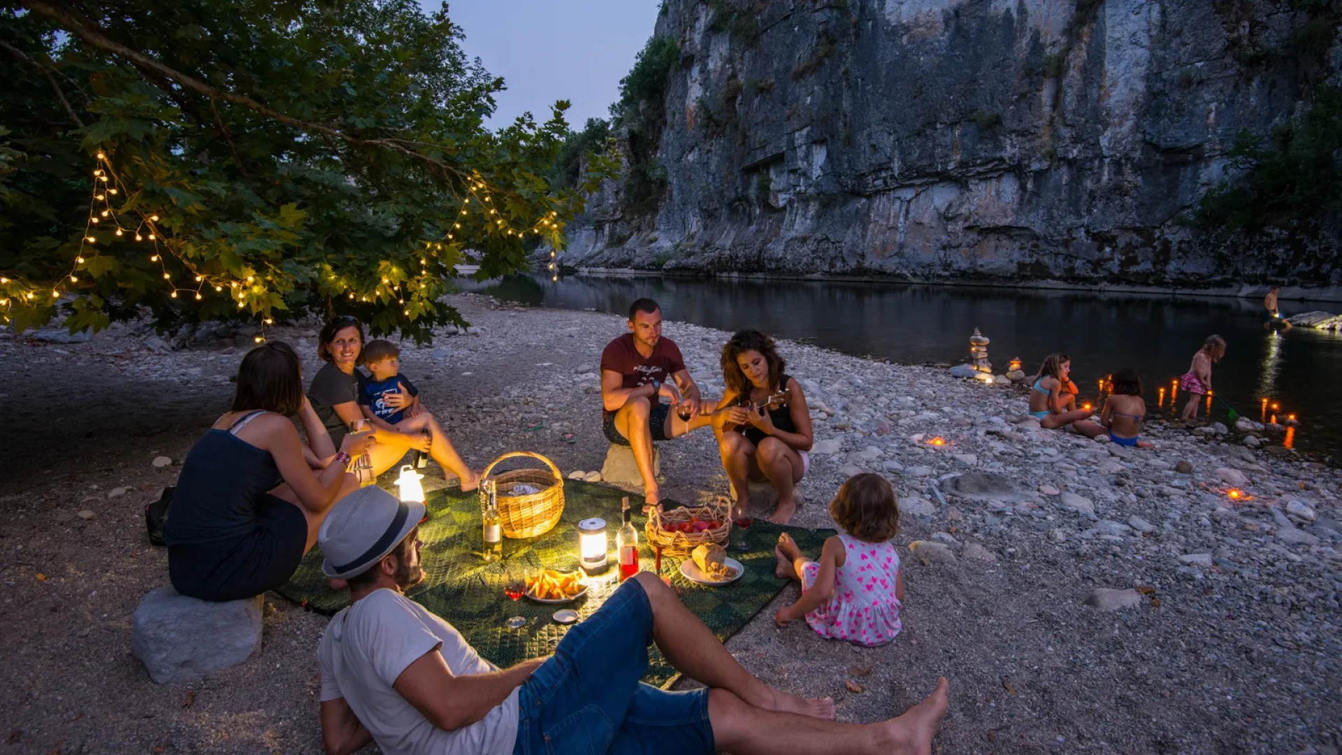 Famille partageant un pique-nique au bord de l'eau, lors d'une soirée d'été
