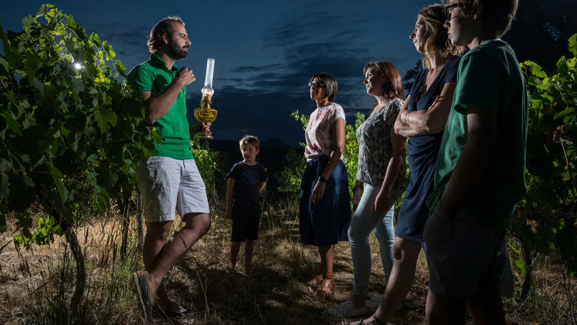 Famille profitant d'un visite nocturne dans les vignes du Domaine des lèbres, en été