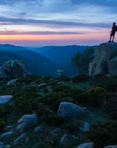 Homme observant le coucher de soleil sur les montagnes de Montselgues