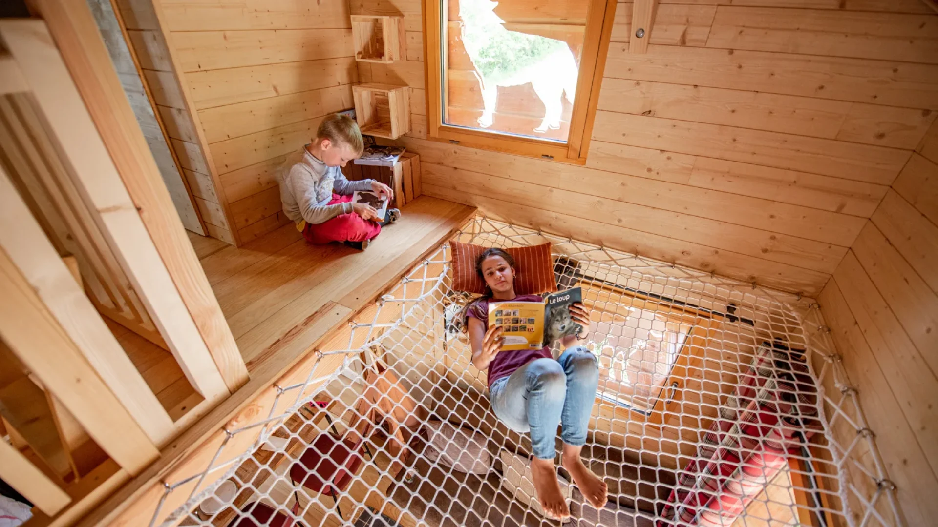 Enfant se détendant dans un hébergement insolite : les "Cabanes perchées" du Safari de Peaugres