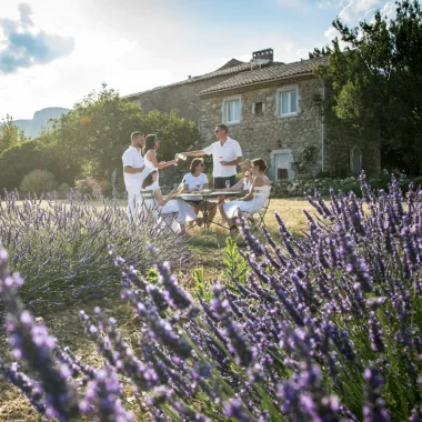 Groupe d'amis prenant l'apéro à l'extérieur de leur gîte, parmi les lavandes