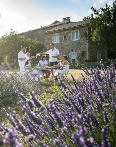 Groupe d'amis prenant l'apéro à l'extérieur de leur gîte, parmi les lavandes