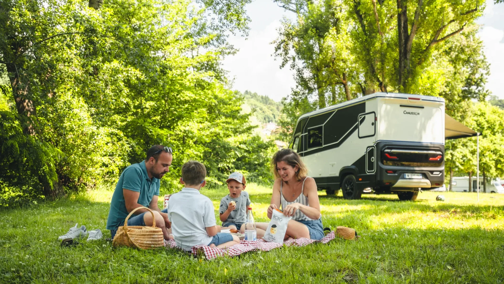 Famille partageant un pique-nique sur une aire de camping-car