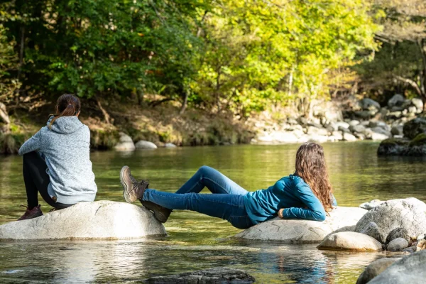 Deux femmes se détendant au bord de la rivière en automne