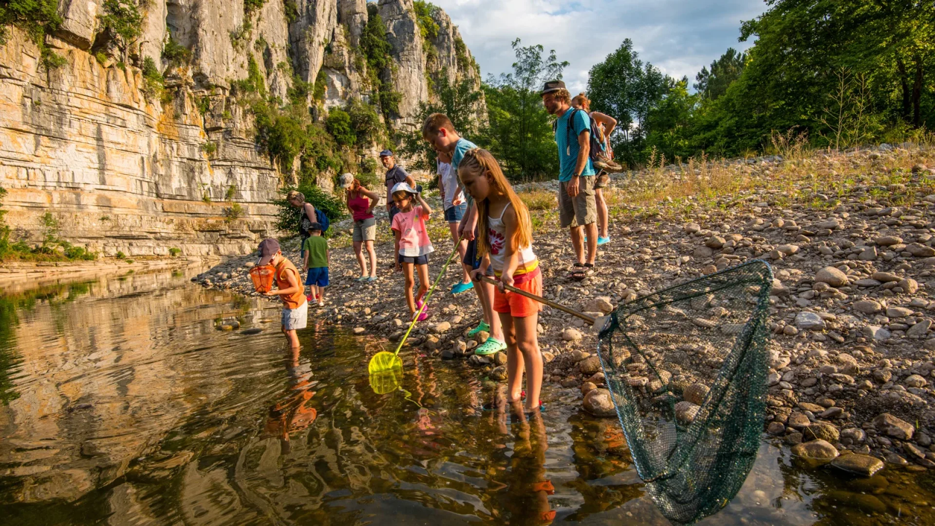 Enfants participant à une animation nature, à la découverte des animaux de la rivière, en été