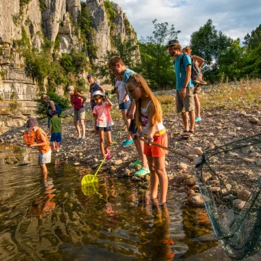 Enfants participant à une animation nature, à la découverte des animaux de la rivière, en été
