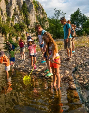Enfants participant à une animation nature, à la découverte des animaux de la rivière, en été