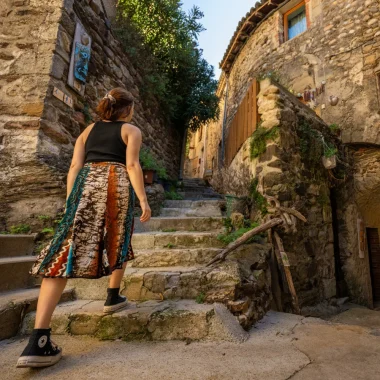 Couple déambulant dans une ruelle du village de caractère de Beauchastel, en été