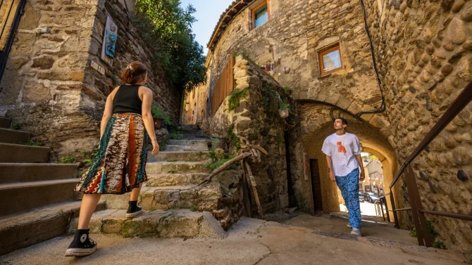 Couple déambulant dans une ruelle du village de caractère de Beauchastel, en été