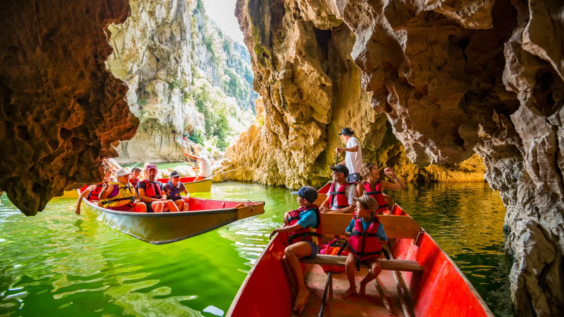 Famille faisant une balade en barque avec les Bateliers de l'Ardèche en été, au Pont d'Arc, dans les Gorges de l'Ardèche